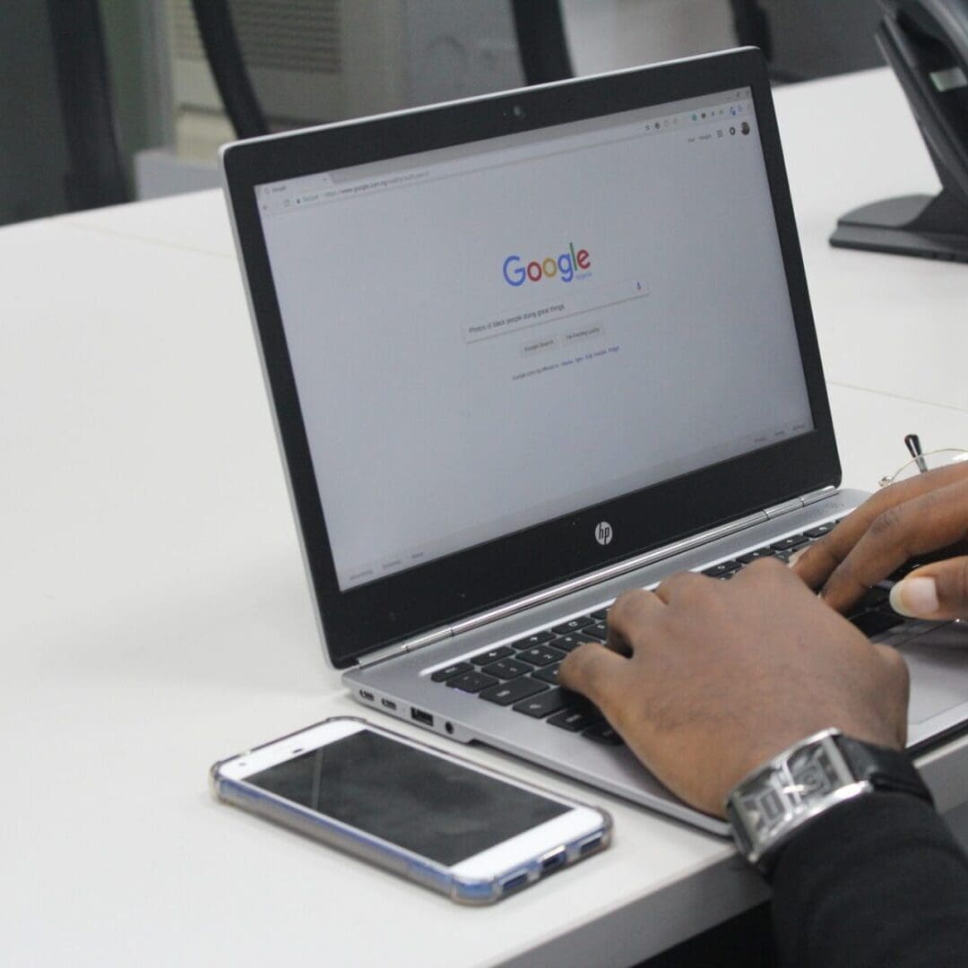 A person using a laptop on top of a table.